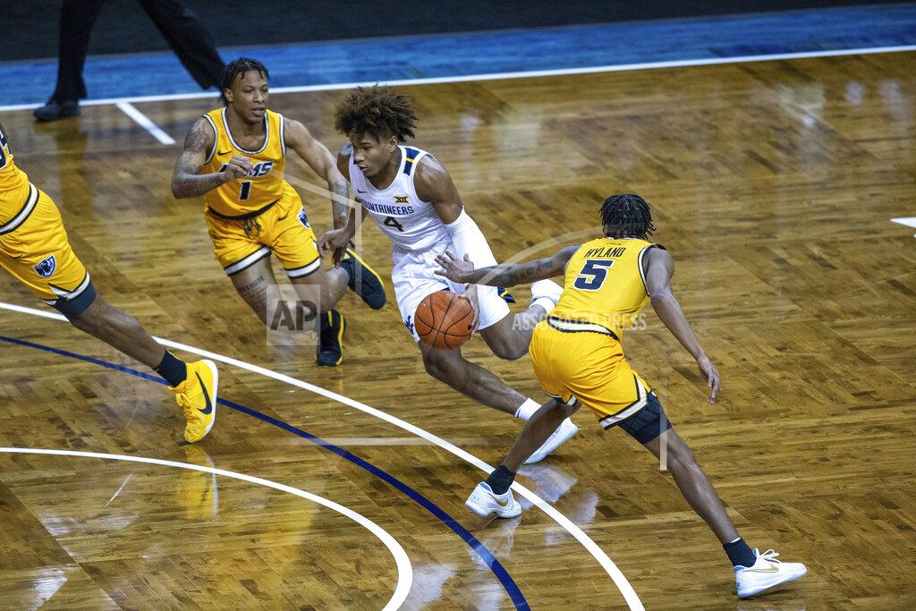 Josh Jurgens West Virginia guard Mile McBride (4) drives to the basket between two VCU defenders during the first half of an NCAA college basketball game Thursday, Nov. 26, 2020, in SIoux Falls, S.D. (AP Photo/Josh Jurgens)