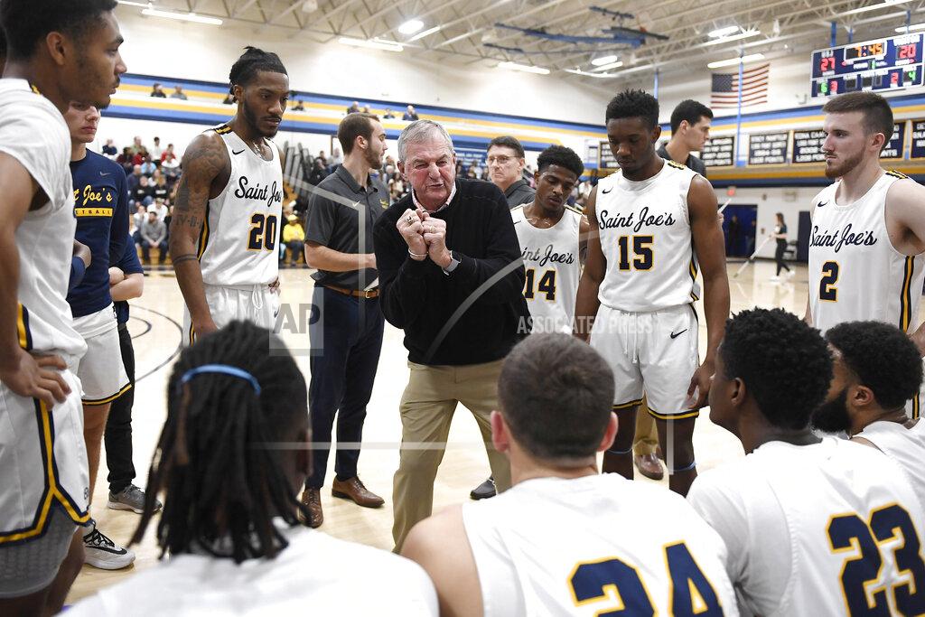 FILE - Saint Joseph coach Jim Calhoun, center, talks to his team during a timeout in the first half of an NCAA college basketball game against Pratt Institute, Jan. 10, 2020, in West Hartford, Conn. Calhoun, who led UConn to three national titles, has retired again, this time from Division III Saint Joseph. (AP Photo/Jessica Hill, File)