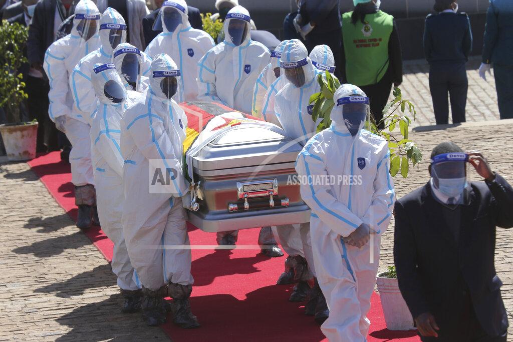 Tsvangirayi Mukwazhi Health officials carry the coffin of Zimbabwean minister Perence Shiri, who died of Covid-19, during his burial in Harare, Friday, July, 31, 2020. Zimbabwes capital, Harare, was deserted Friday, as security agents vigorously enforced the countrys lockdown amidst planned protests. (AP Photo/Tsvangirayi Mukwazhi)