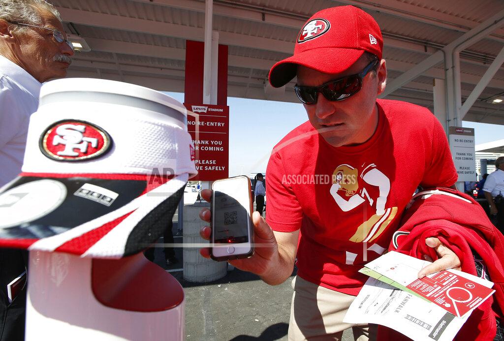 Tony Avelar FILE - In this Aug. 17 2014, file photo, a fan uses a smart phones to scan tickets at Levi's Stadium before an NFL preseason football game between the San Francisco 49ers and the Denver Broncos in Santa Clara, Calif. Tickets have widely transitioned from paper souvenirs to smartphone screens. These tools are an important piece of the reopening puzzle. They also further test a fan’s willingness to potentially sacrifice a little more privacy in an increasingly wired-in world in exchange for the opportunity to sit courtside or behind the plate again. (AP Photo/Tony Avelar, File)