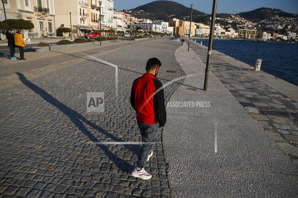 Thanassis Stavrakis An Afghan father walks, at the port of Vathy on the eastern Aegean island of Samos, Greece, Monday, Feb. 22, 2021. On a hill above a small island village, the sparkling blue of the Aegean just visible through the pine trees, lies a boy’s grave. His first ever boat ride was to be his last - the sea claimed him before his sixth birthday. His 25-year-old father, like so many before him, had hoped for a better life in Europe, far from the violence of his native Afghanistan. But his dreams were dashed on the rocks of Samos, a picturesque Greek island almost touching the Turkish coast. Still devastated from losing his only child, the father has now found himself charged with a felony count of child endangerment. (AP Photo/Thanassis Stavrakis)