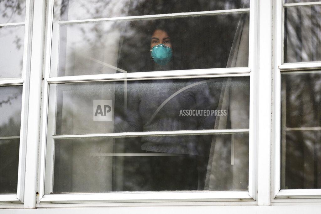 Nam Y. Huh Francy Sandoval looks outside from her home in Melrose Park, Ill., Thursday, April 23, 2020. She works as a receptionist at a community health clinic which treats multiple COVID-19 cases. She has to isolate herself in the attic as soon as she comes home from work each day and is terrified of infecting her family. (AP Photo/Nam Y. Huh)