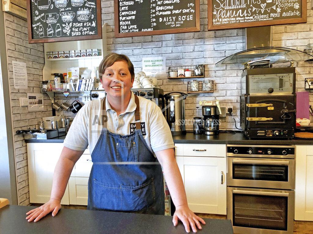 Tom Wilkinson Caroline Atkinson, owner of the Rose Coffee House poses for a photo as she prepares to reopen, in Belmont, Durham, England, Thursday May 13, 2021. Travelers are packing their bags, café-owners are polishing their cutlery and stage performers are warming up as Britain prepared for a major step out of lockdown. But excitement at the reopening of travel and hospitality vied with anxiety about a more contagious variant spreading in the country (Tom Wilkinson/PA via AP)
