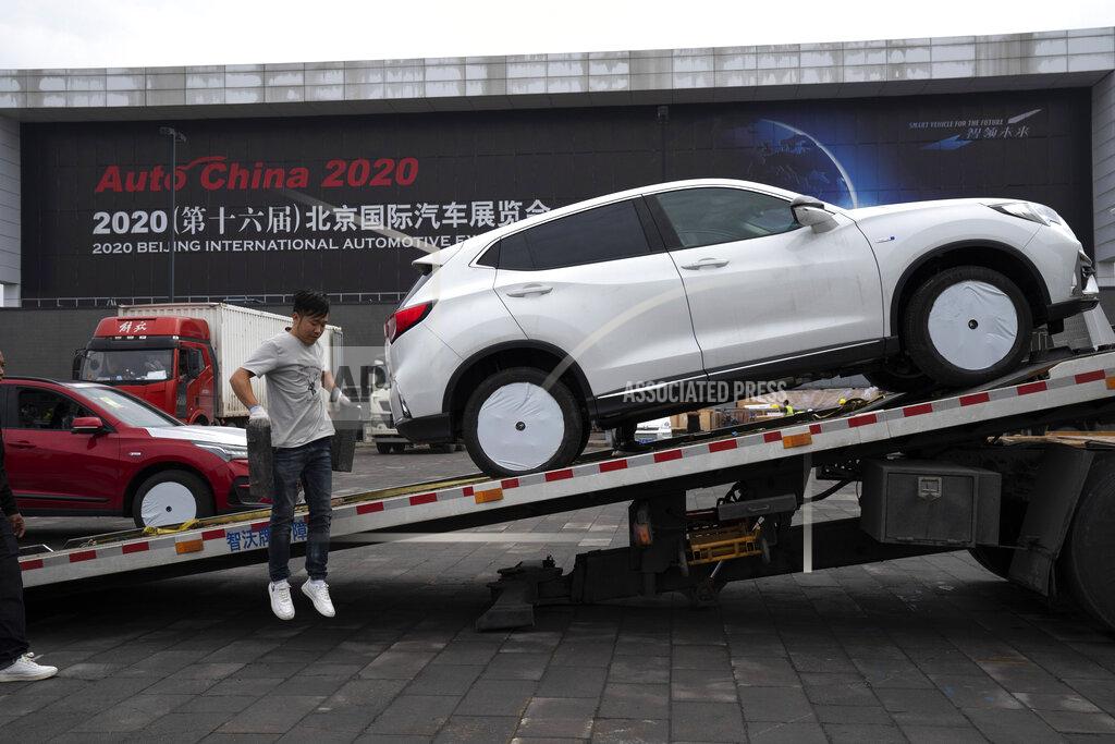 Ng Han Guan Cars are delivered for the upcoming Auto China 2020 show in Beijing on Thursday, Sept. 24, 2020. Auto executives are flying in early to wait out a coronavirus quarantine ahead of the Beijing auto show, the year's biggest sales event for a global industry that is struggling with tumbling sales and layoffs. (AP Photo/Ng Han Guan)