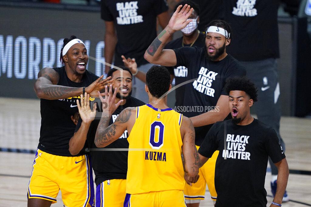 Ashley Landis Los Angeles Lakers' Kyle Kuzma (0) is congratulated by teammates after hitting a game-winning 3-pointer against the Denver Nuggets during the second half of an NBA basketball game Monday, Aug. 10, 2020, in Lake Buena Vista, Fla. The Lakers won 124-121. (AP Photo/Ashley Landis, Pool)