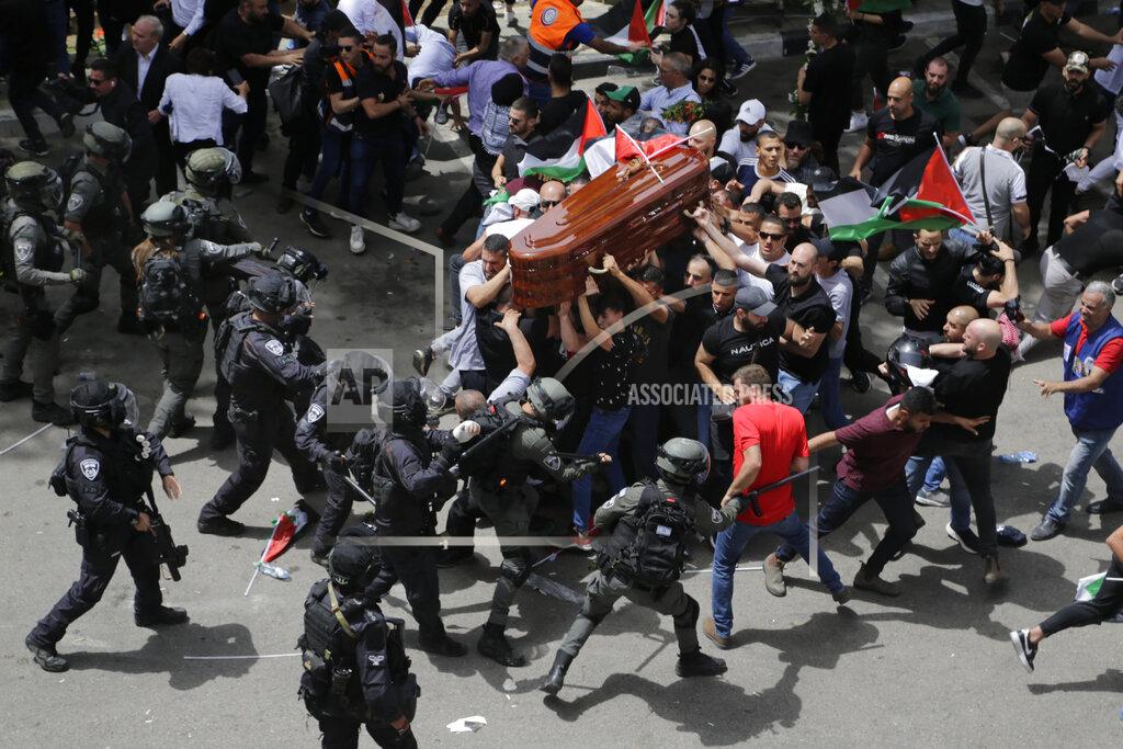 Maya Levin Israeli police confront with mourners as they carry the casket of slain Al Jazeera veteran journalist Shireen Abu Akleh during her funeral in east Jerusalem, Friday, May 13, 2022. Abu Akleh, a Palestinian-American reporter who covered the Mideast conflict for more than 25 years, was shot dead Wednesday during an Israeli military raid in the West Bank town of Jenin. (AP Photo/Maya Levin)