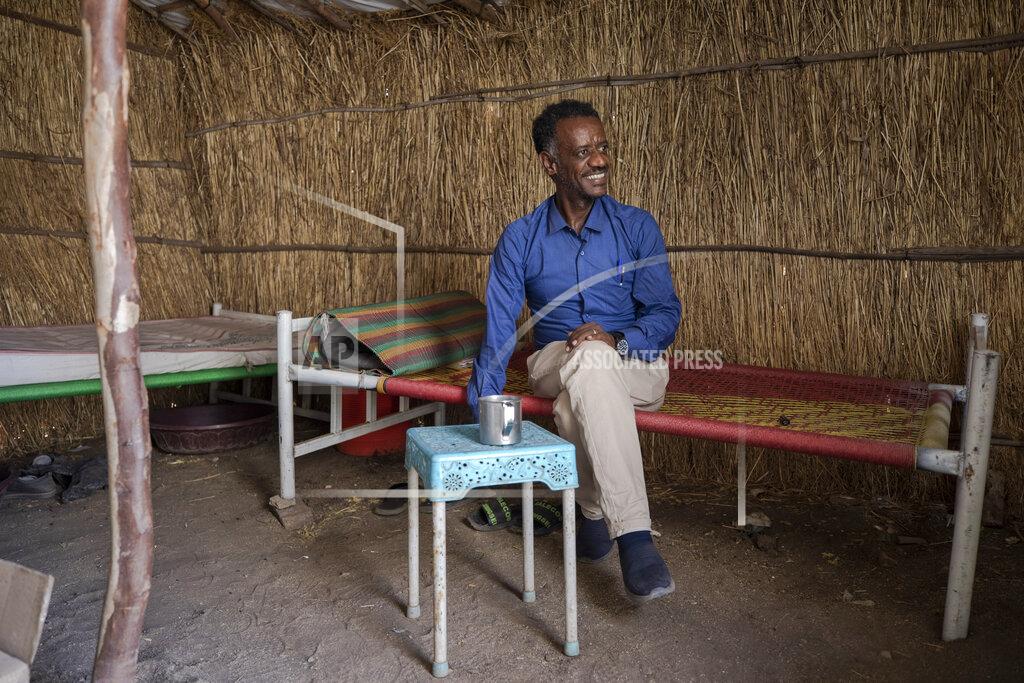Nariman El-Mofty Surgeon and doctor-turned-refugee, Dr. Tewodros Tefera, takes a cigarette break inside his shelter at the Sudanese Red Crescent clinic where he works, in Hamdayet, eastern Sudan, near the border with Ethiopia, on March 22, 2021. (AP Photo/Nariman El-Mofty)