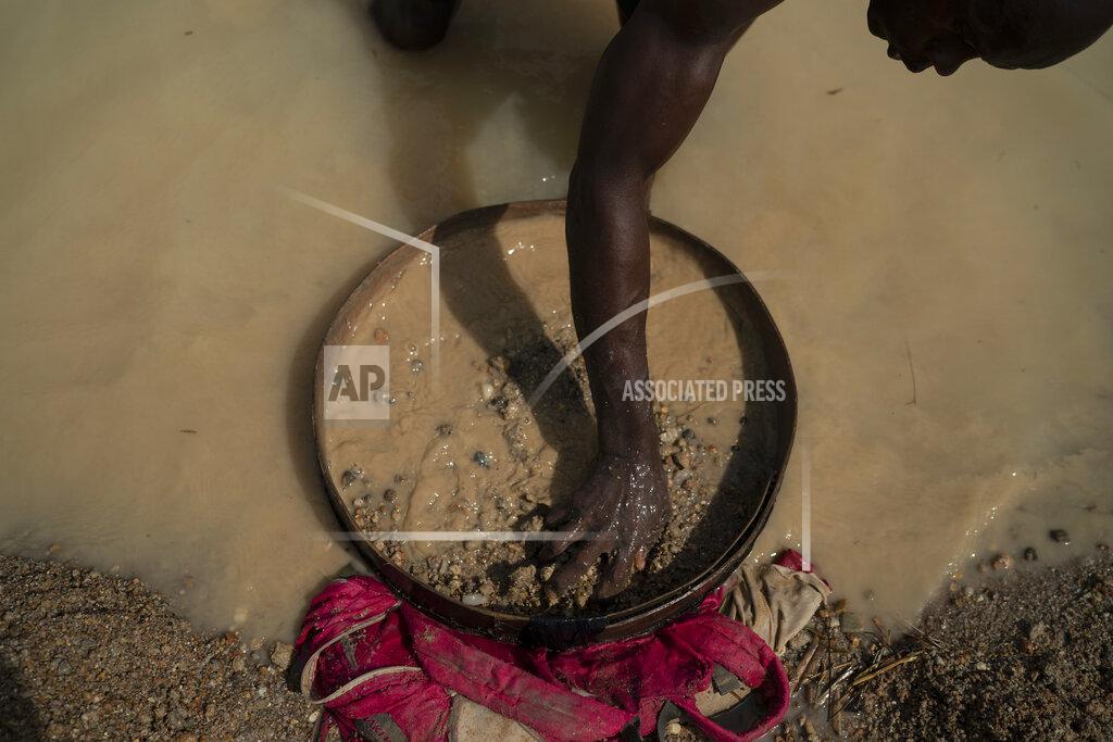 Leo Correa Aiah Kemoh uses a sieve as he looks for diamonds in a mining site in Koidu, district of Kono, Sierra Leone, Sunday, Nov. 22, 2020. The 43-year-old miner went back to mining just after the coronavirus restriction measures were lifted. "It's been difficult", says Kemoh, who built his family house with the money he earned from the diamonds. (AP Photo/Leo Correa)