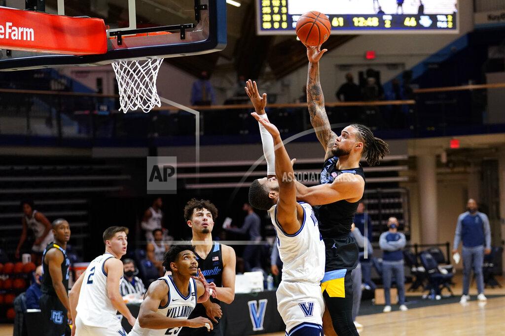 Matt Slocum Marquette's Theo John, right, goes up for a shot against Villanova's Eric Dixon during the second half of an NCAA college basketball game, Wednesday, Feb. 10, 2021, in Villanova, Pa. (AP Photo/Matt Slocum)