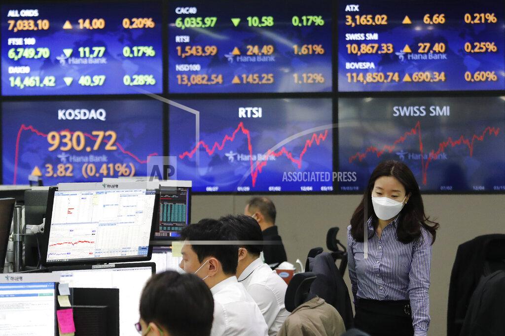 Ahn Young-Joon A currency trader passes by screens showing foreign exchange rates at the foreign exchange dealing room of the KEB Hana Bank headquarters in Seoul, South Korea, Tuesday, March 16, 2021. Asian shares mostly rose on Tuesday, cheered by a rally to all-time highs on Wall Street, though worries over the slow pace of coronavirus vaccinations in the region were weighing on sentiment. (AP Photo/Ahn Young-joon)