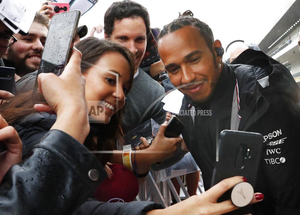 Marco Ugarte Mercedes driver Lewis Hamilton poses for photos with his fans during an autograph signing opportunity, ahead of the Formula One Grand Prix, in Mexico City, Thursday, Oct. 24, 2019. (AP Photo/Marco Ugarte)