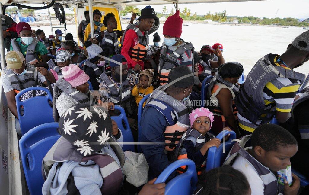 Fernando Vergara Haitian migrants sit in a boat that will take them to Acandi, near the border with Panama, as they depart Necocli, Colombia, Monday, Sept. 13, 2021. Migrants have been gathering in Necocli as they move north on their way to the U.S. border. (AP Photo/Fernando Vergara)