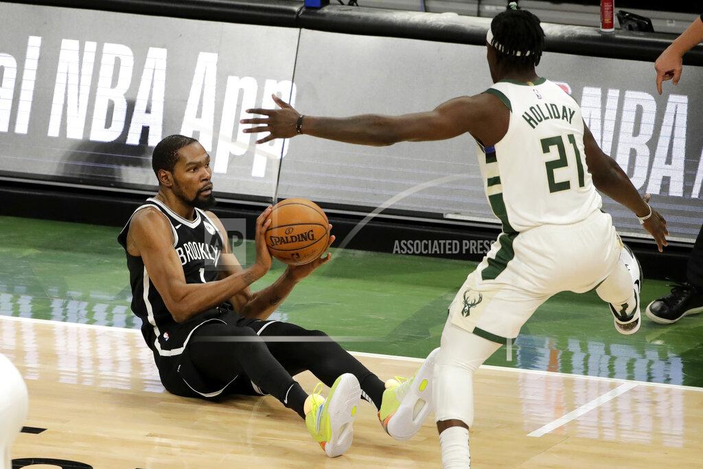 Aaron Gash Brooklyn Nets' Kevin Durant, left, looks to pass against Milwaukee Bucks' Jrue Holiday, right, after falling to the floor during the second half of an NBA basketball game Tuesday, May 4, 2021, in Milwaukee. (AP Photo/Aaron Gash)