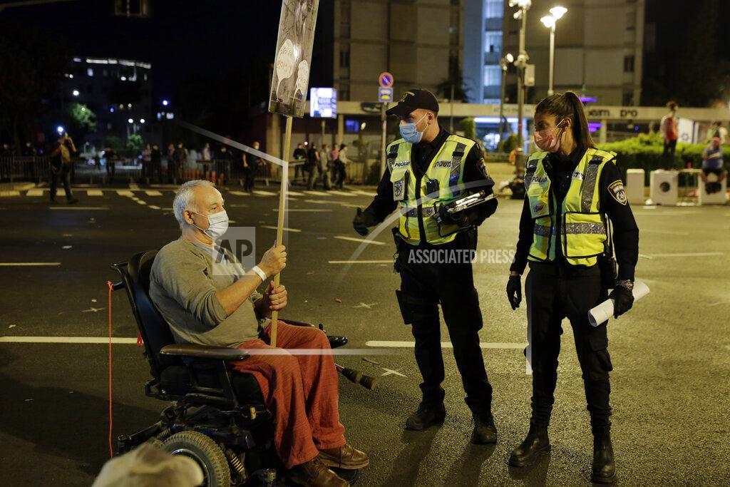 Maya Alleruzzo Police ask a protester in a wheelchair to move after security personnel forcibly cleared the square outside of Prime Minister Benjamin Netanyahu's residence in Jerusalem, early Sunday, Sept. 27, 2020, during a three-week nationwide lockdown in Israel to curb the spread of the coronavirus. (AP Photo/Maya Alleruzzo)