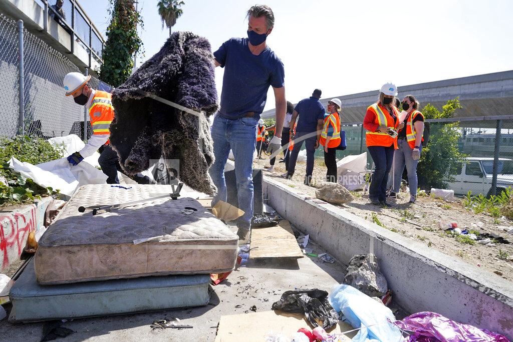 Marcio Jose Sanchez California Gov. Gavin Newsom joins a cleanup effort Tuesday, May 11, 2021, in Los Angeles. Newsom on Tuesday proposed $12 billion in new funding to get more people experiencing homelessness in the state into housing and to "functionally end family homelessness" within five years. (AP Photo/Marcio Jose Sanchez)