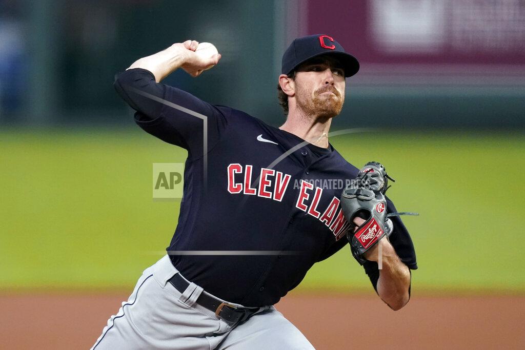 FILE - In this Aug. 31, 2020, file photo, Cleveland Indians starting pitcher Shane Bieber throws during the first inning of the team's baseball game against the Kansas City Royals in Kansas City, Mo. Indians ace Shane Bieber recently tested positive with COVID-19, delaying the AL Cy Young winner's arrival at training camp. President of baseball operations Chris Antonetti said Thursday, Feb. 18, 2021, that Bieber has only dealt with “very mild symptoms” from the virus. Antonetti anticipates that Bieber, who had been working out at the team's training complex in Goodyear, Arizona, will join the club in the next few days.(AP Photo/Charlie Riedel, File)