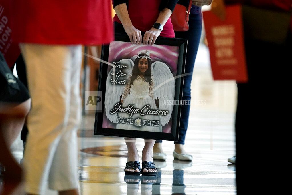 Eric Gay A member of Moms Demand Action holds a photo of Jacklyn Cazares, who was one of 19 children killed at Robb Elementary School, outside of a hearing at the state capitol, Thursday, June 23, 2022, in Austin, Texas. (AP Photo/Eric Gay)