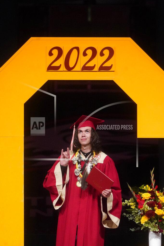 Rick Bowmer Elijah Wiggins crosses the stage to accept his diploma wearing an eagle feather during the graduation from Cedar City High School on Wednesday, May 25, 2022, in Cedar City, Utah. (AP Photo/Rick Bowmer)