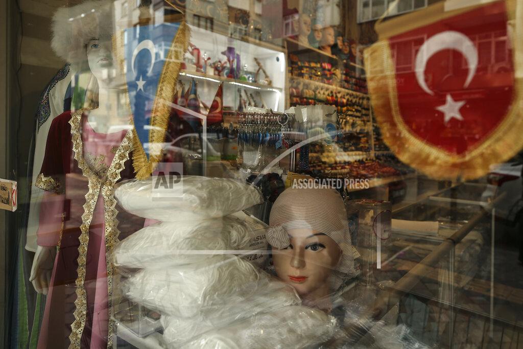 Emrah Gurel A window of a clothes shop belonging to a member of the Uighur community is decorated with a Turkish flag and one of what ethnic Uighurs call 'East Turkestan', in Istanbul, Tuesday, Feb. 2, 2021. Because of shared cultural ties, Turkey has long been a safe haven for the Uighurs, a Turkic group native to China's far west Xinjiang region. Opposition legislators in Turkey are accusing Ankara's leaders of secretly selling out Uighurs to China in exchange for coronavirus vaccines.(AP Photo/Emrah Gurel)