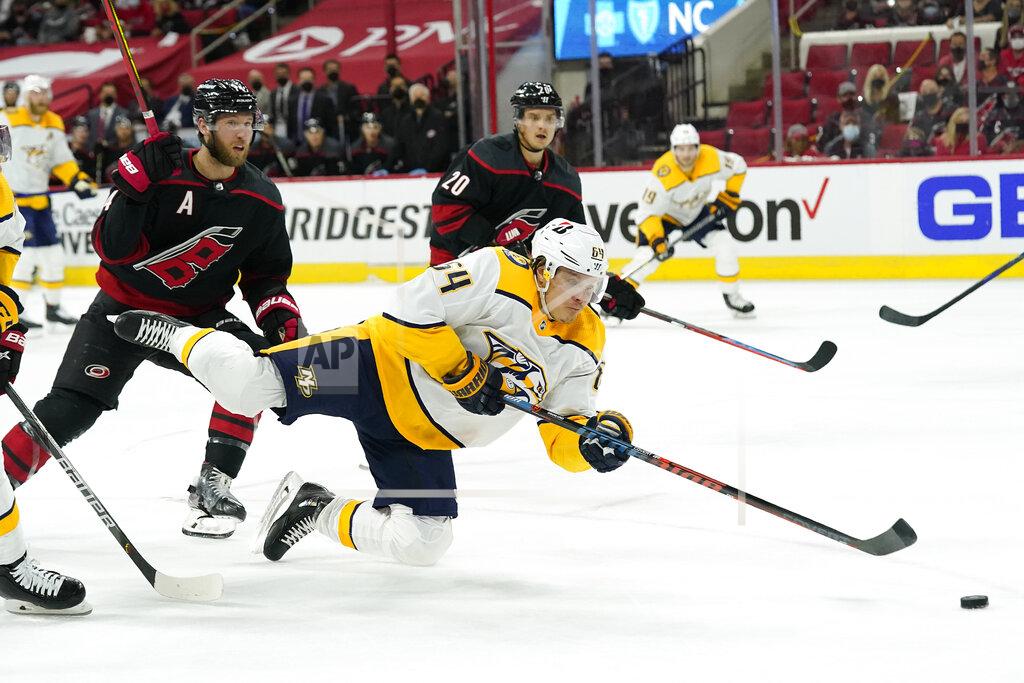 Gerry Broome Nashville Predators center Mikael Granlund (64) falls to the ice while trying to take a shot on goal while Carolina Hurricanes' Jaccob Slavin defends at left during the first period in Game 5 of an NHL hockey Stanley Cup first-round playoff series in Raleigh, N.C., Tuesday, May 25, 2021. (AP Photo/Gerry Broome)