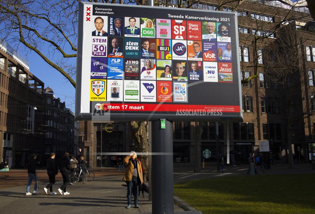 Peter Dejong A man shields his eyes from the sun as he looks up at an election billboard with a multitude of political parties in Amsterdam, Netherlands, Saturday, Feb. 27, 2021. After more than a decade in power, a recent scandal that forced him to resign and a year battling the coronavirus, Dutch Prime Minister Mark Rutte's popularity, heightened by his handling of the pandemic, remains high less than a month before a general election. But it is showing signs of eroding along with support for his country's tough COVID-19 lockdown as the vote approaches. (AP Photo/Peter Dejong)