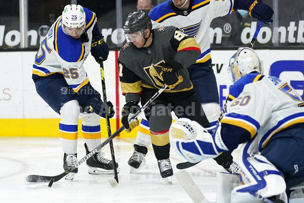 St. Louis Blues center Jordan Kyrou (25) and Vegas Golden Knights center Jonathan Marchessault (81) vie for the puck during the second period of an NHL hockey game Tuesday, Jan. 26, 2021, in Las Vegas. (AP Photo/John Locher)