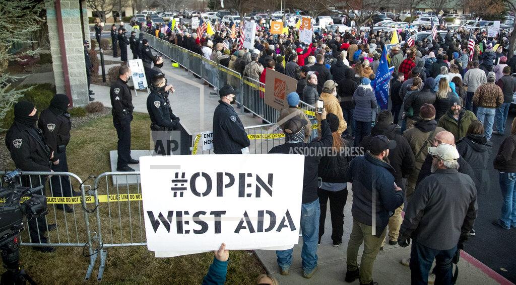 Boise police were forced to create a barrier to keep anti-mask protesters from entering a meeting at the Central District Health offices, Tuesday, Dec. 8, 2020 in Boise, Idaho. The special meeting of the CDH board was later cancelled. (Darin Oswald/Idaho Statesman via AP)