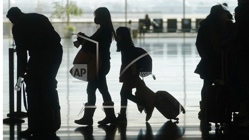 Rick Bowmer FILE - In this Wednesday, March 17, 2021, file photo, travelers walk through the Salt Lake City International Airport, in Salt Lake City. Vaccine passports being developed to verify COVID-19 immunization status and allow inoculated people to more freely travel, shop and dine have become the latest flash point in America’s perpetual political wars, with Republicans portraying them as a heavy-handed intrusion into personal freedom and private health choices. (AP Photo/Rick Bowmer, File)
