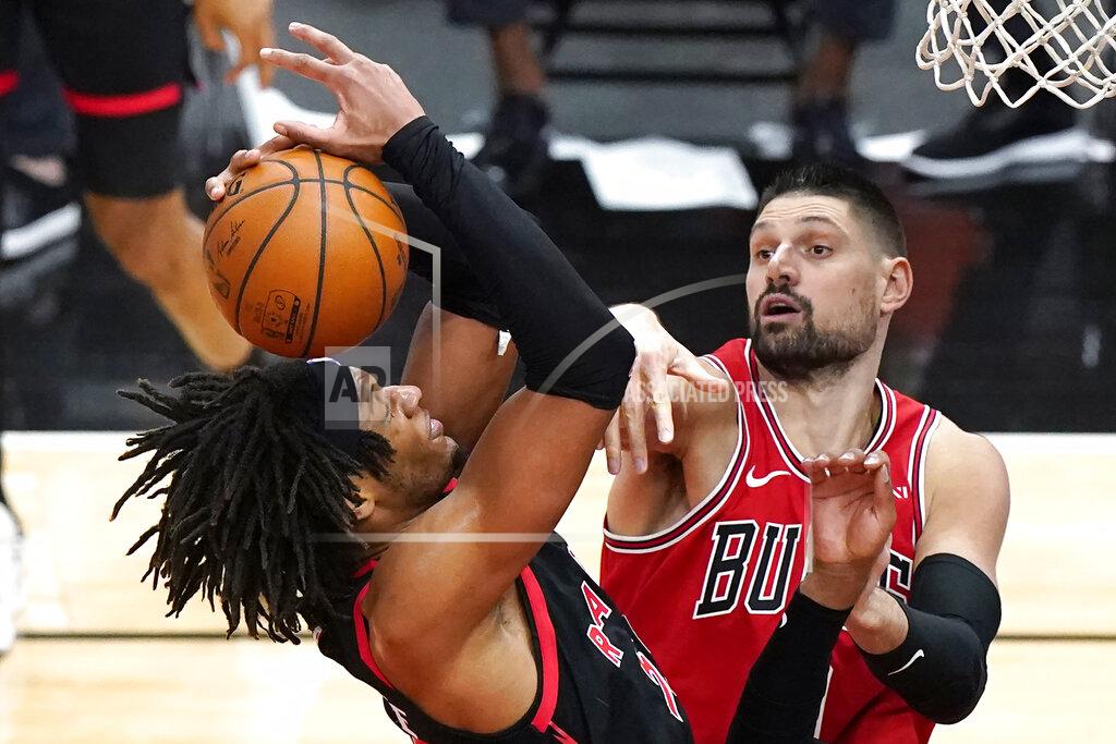Nam Y. Huh Toronto Raptors forward Freddie Gillespie, left, grabs a rebound next to Chicago Bulls center Nikola Vucevic during the second half of an NBA basketball game in Chicago, Thursday, May 13, 2021. The Bulls won 114-102. (AP Photo/Nam Y. Huh)