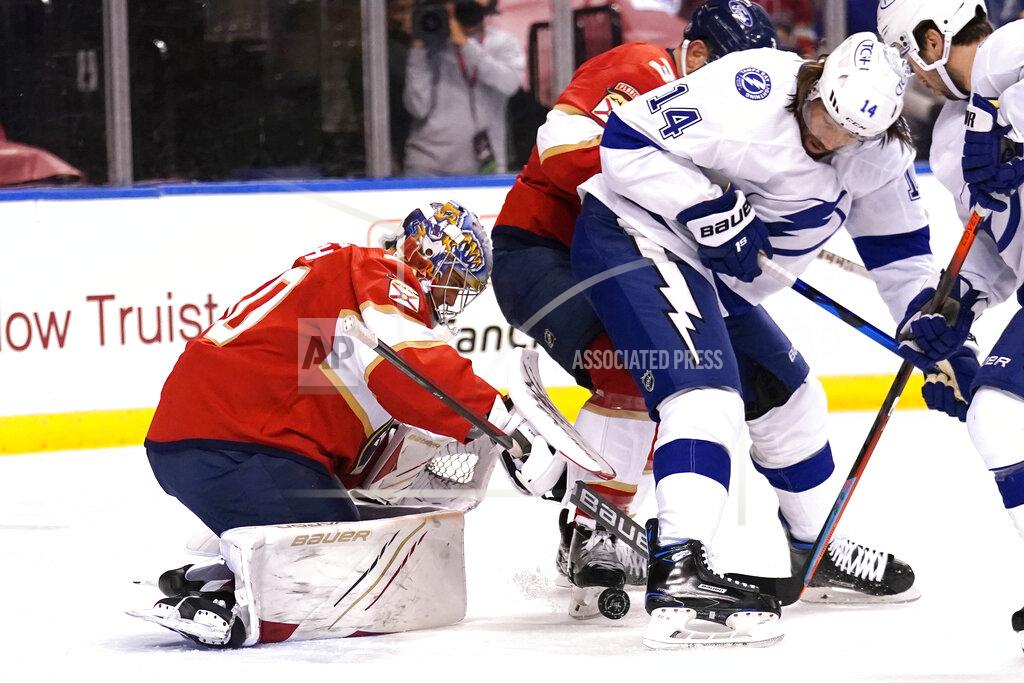 Lynne Sladky Florida Panthers goaltender Spencer Knight, left, goes against Tampa Bay Lightning left wing Pat Maroon (14) as he stops a shot on the goal during the first period in Game 5 of an NHL hockey Stanley Cup first-round playoff series, Monday, May 24, 2021, in Sunrise, Fla. (AP Photo/Lynne Sladky)