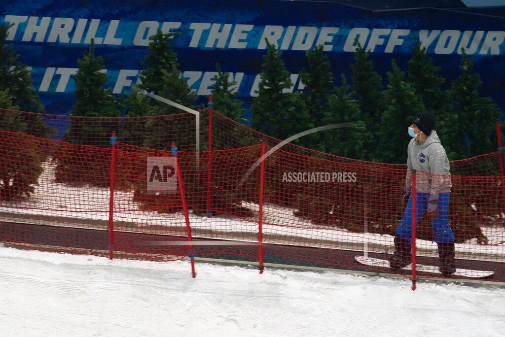 Jon Gambrell A snowboarder heads up the hill at Ski Dubai in Mall of the Emirates in Dubai, United Arab Emirates, Wednesday, May 27, 2020. Dubai on Wednesday loosed its restrictions imposed over the coronavirus pandemic, allowing movie theaters and other attractions to operate. (AP Photo/Jon Gambrell)