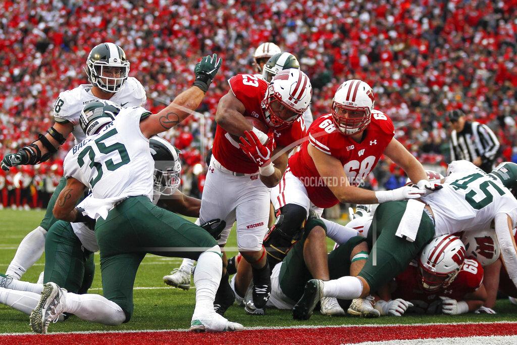 Andy Manis Wisconsin running back Jonathan Taylor (23) scores a touchdown against Michigan State linebacker Joe Bachie (35) during the second half of an NCAA college football game Saturday, Oct. 12, 2019, in Madison, Wis. Wisconsin won 38-0. (AP Photo/Andy Manis)
