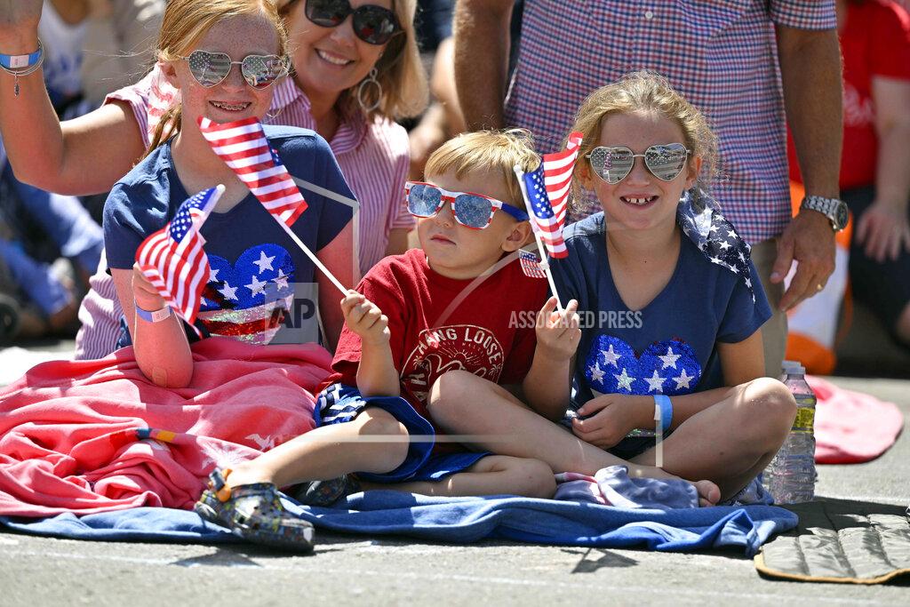 Jeff Gritchen Lesley McMillan, along with her kids, Johnelle, left, Hayden and Jolynn watch the 118th Huntington Beach 4th of July Parade on Main Street in Huntington Beach, Calif., on Monday, July 4, 2022. (Jeff Gritchen/The Orange County Register via AP)