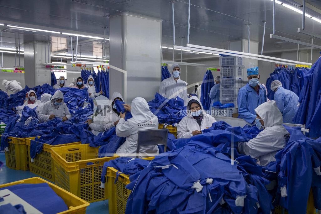 Nariman El-Mofty Women working at Medic Egypt for Medical Clothes company, make protective face masks to be used to help curb the spread of the coronavirus at a factory in Menoufiya, Egypt, Saturday, June 6, 2020. Egypt has officially ordered its people to wear face masks in public and private transportation, inside government business and offices as it is easing the partial lockdown imposed. Prime Minister Mustafa Madbouly has said violators would be fined as the country has seen a jump of daily reported infections in the past week. (AP Photo/Nariman El-Mofty)