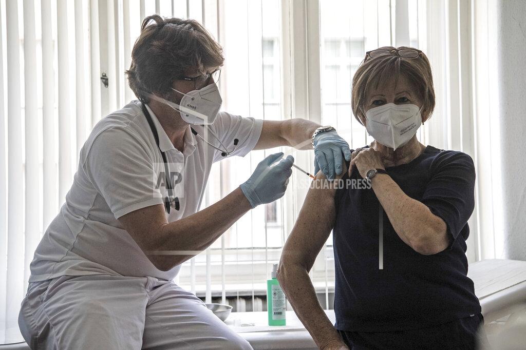 Paul Zinken Patient Nicole Brusselaers, right, is vaccinated against the coronavirus with the Pfizer vaccine by family doctor Karl Schorn, left, in Berlin, Germany, Thursday, April 8, 2021. (Paul Zinken/dpa via AP)