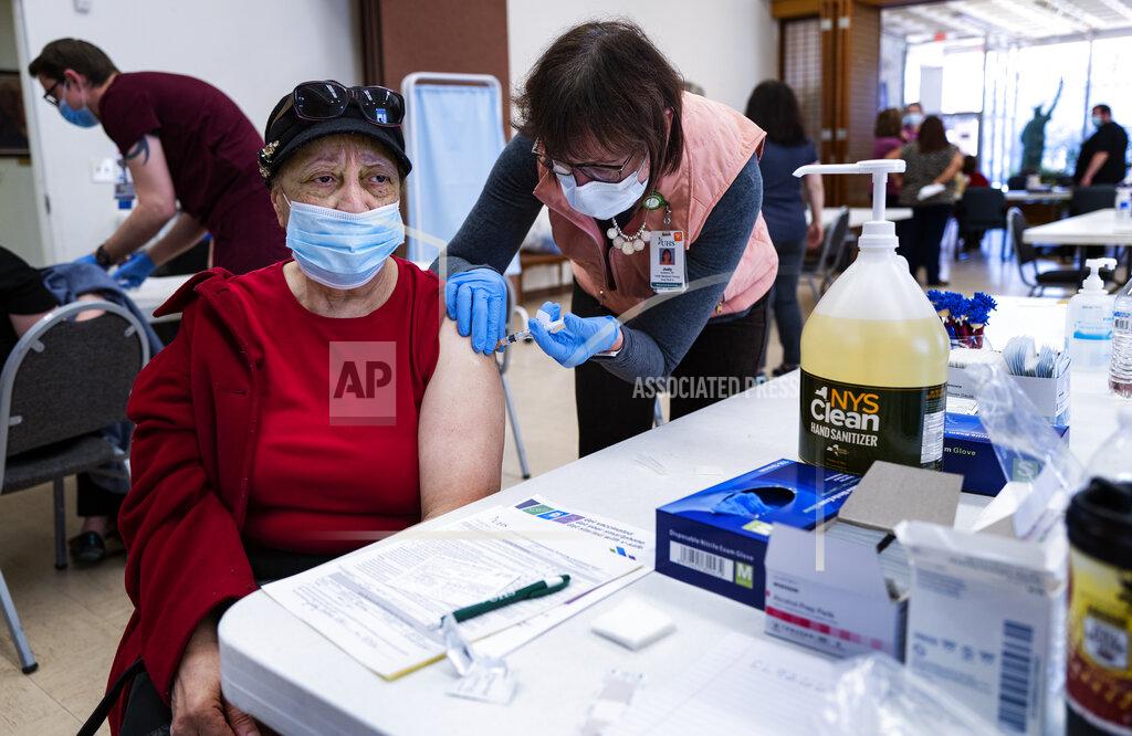Craig Ruttle FILE - Elsie Logan, of Binghamton, N.Y., receives a COVID-19 vaccine by physician assistant Judy Andrews at a pop-up clinic at the American Civic Association (ACA) in Binghamton, N.Y., Friday, March 19, 2021. New York will lift more COVID-19 rules once 70% of adults have at least one shot of a COVID-19 vaccine, a target that Gov. Andrew Cuomo said Monday he hoped his state could reach in days.(AP Photo/Craig Ruttle, File)