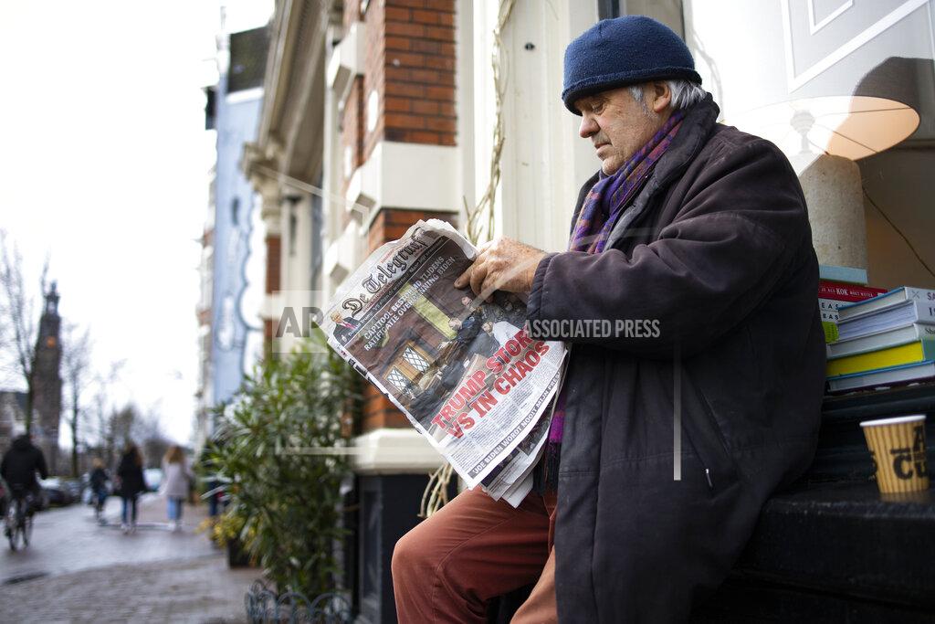 Peter Dejong A man turns a page as he reads a newspaper with a headline reading "Trump Plunges U.S. into Chaos" outside a takeaway cafe in the center of Amsterdam, Netherlands, Thursday, Jan. 7, 2021. Congress confirmed Democrat Joe Biden as the presidential election winner early Thursday after a violent mob loyal to President Donald Trump stormed the U.S. Capitol in a stunning attempt to overturn America's presidential election, undercut the nation's democracy and keep Trump in the White House. (AP Photo/Peter Dejong)