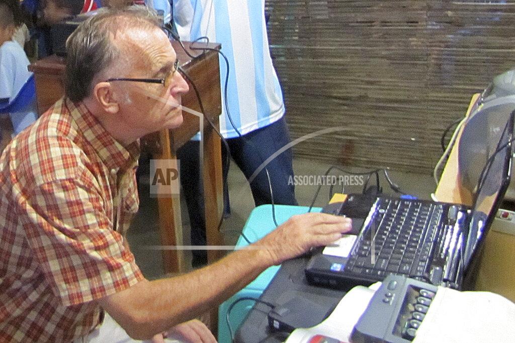 Uncredited This 2010 photo provided to The Associated Press shows now-defrocked Catholic priest Richard Daschbach using a computer at the Topu Honis children's shelter in Kutet, East Timor. Daschbach is wanted in the U.S. for three counts of wire fraud linked to one of his California-based donors, which accused him in a court case of violating an agreement that he would protect those under his care. An Interpol Red Notice has been issued internationally for his arrest. (AP Photo)