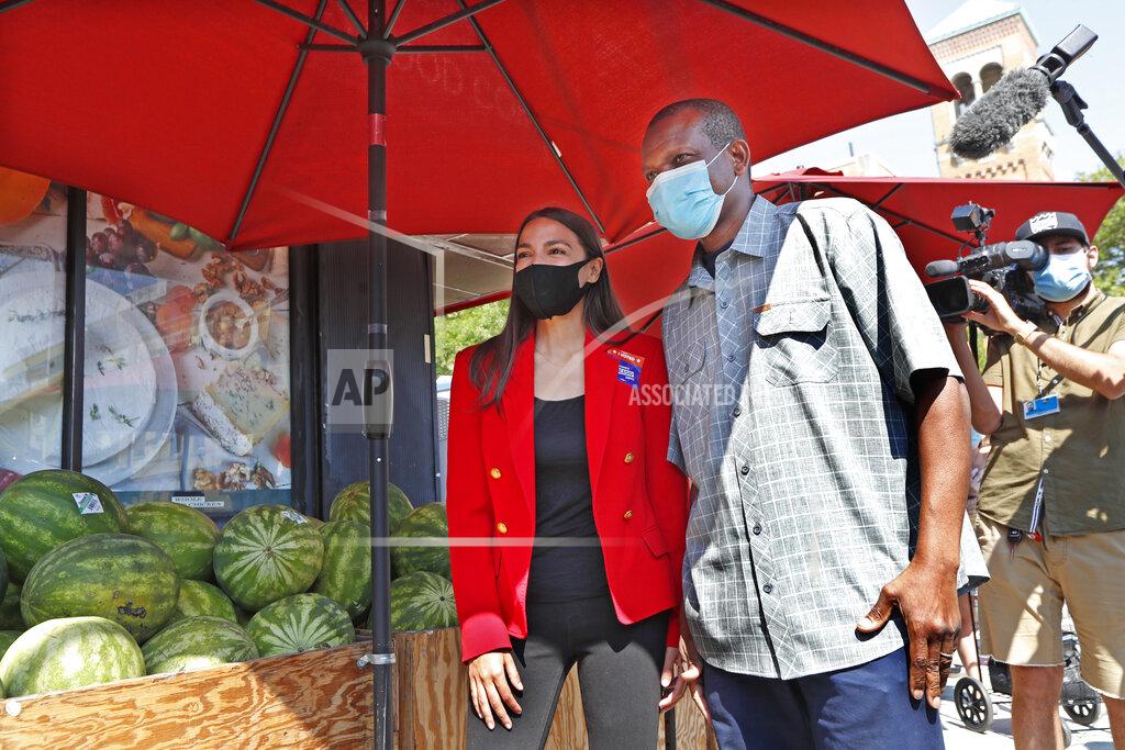 Kathy Willens U.S. Rep. Alexandria Ocasio-Cortez, D-N.Y., left, poses for a cell phone photograph with a supporter while greeting voters during the state's primary election outside a grocery store in the Astoria neighborhood of the Queens borough of New York, Tuesday, June 23, 2020. The first term Democrat is facing several challenges in her bid to hold onto her congressional seat. (AP Photo/Kathy Willens)