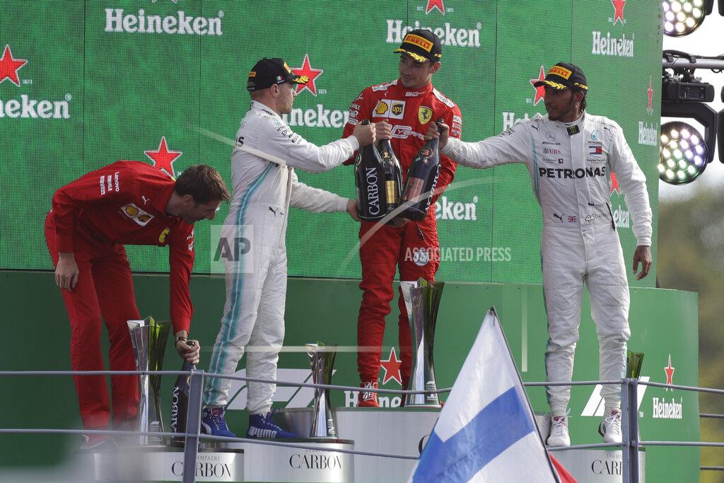 Luca Bruno Ferrari driver Charles Leclerc of Monaco, second right, celebrates with third placed Mercedes driver Lewis Hamilton of Britain, right, and second place Mercedes driver Valtteri Bottas of Finland, second left on podium after winning the Formula One Italy Grand Prix at the Monza racetrack, in Monza, Italy, Sunday, Sept. 8, 2019. (AP Photo/Luca Bruno)