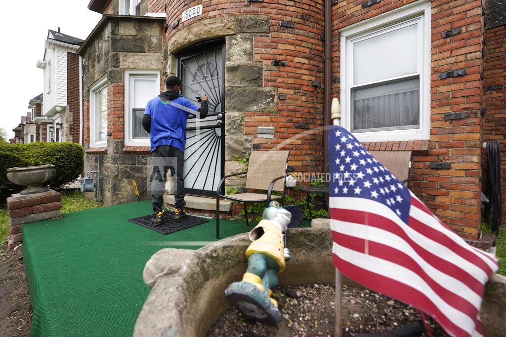 Paul Sancya Sirgregory Allen leaves a flyer at a home in Detroit, Tuesday, May 4, 2021. Officials are walking door-to-door to encourage residents of the majority Black city to get vaccinated against COVID-19 as the city's immunization rate lags well behind the rest of Michigan and the United States. (AP Photo/Paul Sancya)