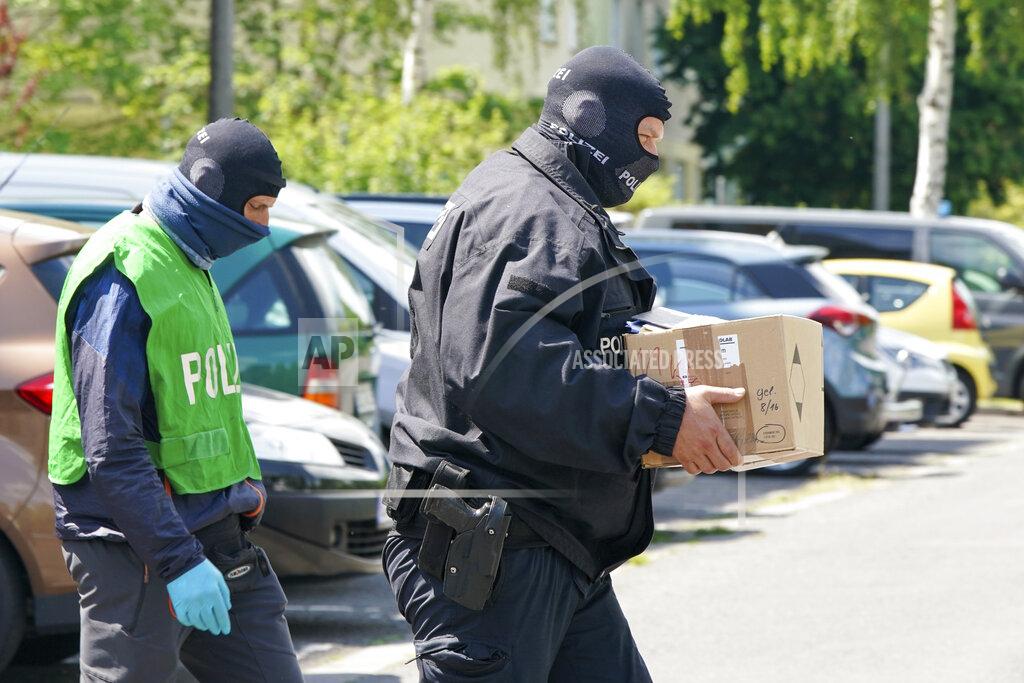 Peter Endig Federal police officers carry a box with secured documents during raids in Leipzig, Germany, Wednesday, May 27, 2020. Police in Germany have raided dozens of homes linked to anti-government groups suspected of manufacturing fake documents. (Peter Endig/dpa via AP)