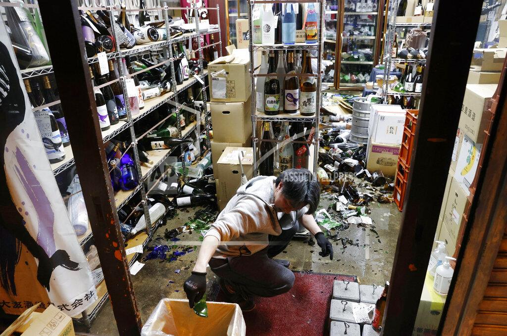 Jun Hirata A liquor shop's manager clears the damaged bottles following an earthquake in Fukushima, northeastern Japan Saturday, Feb. 13, 2021. The Japan Meteorological Agency says a strong earthquake has hit off the coast of northeastern Japan, shaking Fukushima, Miyagi and other areas. (Jun Hirata/Kyodo News via AP)