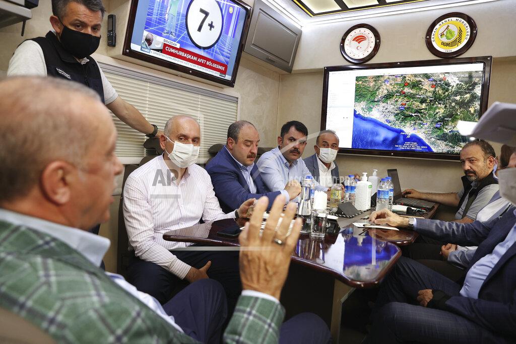 Uncredited Turkey's President Recep Tayyip Erdogan, front, speaks to his ministers about the wildfires in Manavgat, Antalya, Turkey, Saturday, July 31, 2021. The death toll from wildfires raging in Turkey's Mediterranean towns rose to six Saturday after two forest workers were killed, the country's health minister said. Fires across Turkey since Wednesday burned down forests, encroaching on villages and tourist destinations and forcing people to evacuate.(Turkish Presidency via AP, Pool)