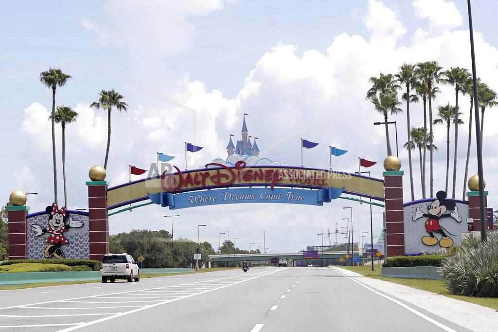 John Raoux Cars drive under a sign greeting visitors near the entrance to Walt Disney World, Thursday, July 2, 2020, in Lake Buena Vista, Fla. Despite a huge surge of Floridians testing positive for the new coronavirus in recent weeks, Magic Kingdom and Animal Kingdom, two of Disney World's four parks are reopening Saturday, July 11. When they do, visitors to “The Most Magical Place on Earth” will find new rules in place. (AP Photo/John Raoux)