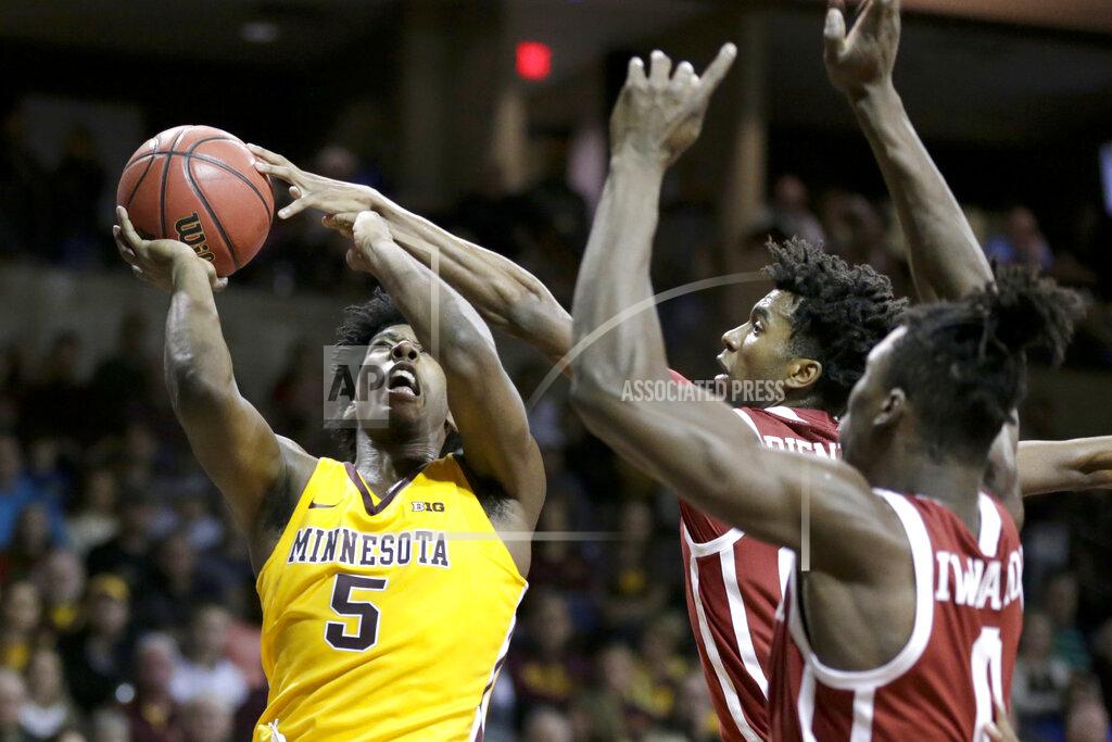 Nati Harnik Oklahoma's Jamal Bieniemy, center, along with Victor Iwuakor (0), blocks a shot by Minnesota's Marcus Carr (5) during the second half of an NCAA college basketball game in Sioux Falls, S.D., Saturday, Nov. 9, 2019. (AP Photo/Nati Harnik)