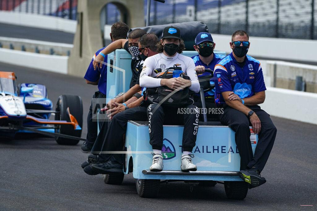 Michael Conroy J.R. Hildebrand, left foreground, rides out to the pit area with his team during practice for the Indianapolis 500 auto race at Indianapolis Motor Speedway in Indianapolis, Friday, Aug. 14, 2020. (AP Photo/Michael Conroy)
