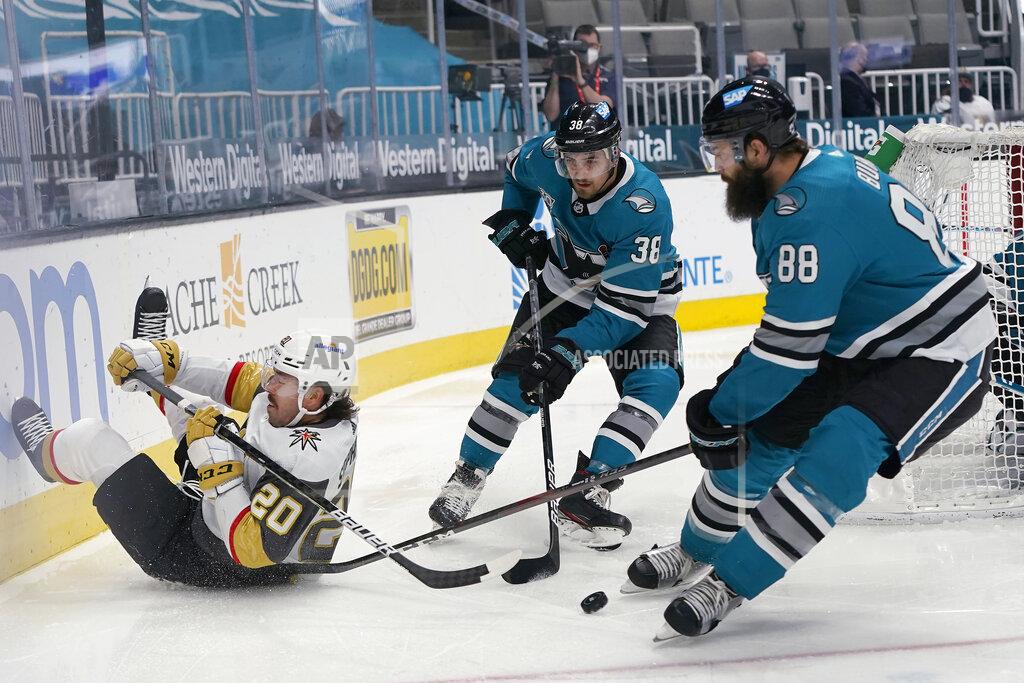 Jeff Chiu Vegas Golden Knights center Chandler Stephenson, left, reaches behind for the puck next to San Jose Sharks defensemen Mario Ferraro (38) and Brent Burns (88) during the second period of an NHL hockey game in San Jose, Calif., Wednesday, May 12, 2021. (AP Photo/Jeff Chiu)
