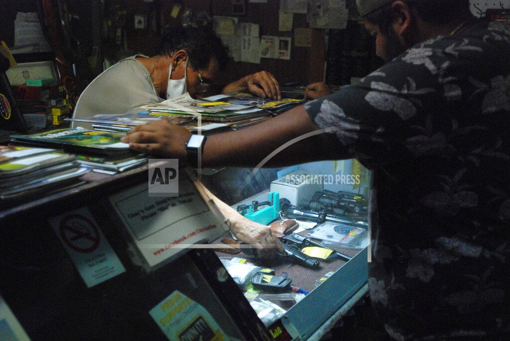 Morgan Lee Gun shop owner Jesus "Chuy" Aguirre, left, attends to customer Angel Zacarias on Thursday, Aug. 26, 2021, in Chuy's Gun Shop in El Paso, Texas, as anticipation builds regarding a new Texas law that relaxes restrictions on handguns. Under the new law, most people age 21 or older who have not been convicted of a felony can carry a holstered handgun — concealed or not — in public without getting a license and related training. Supporters say the changes are a necessary expansion of the so-called constitutional carry movement that will allow people to more easily defend themselves without government interference. (AP Photo/Morgan Lee)