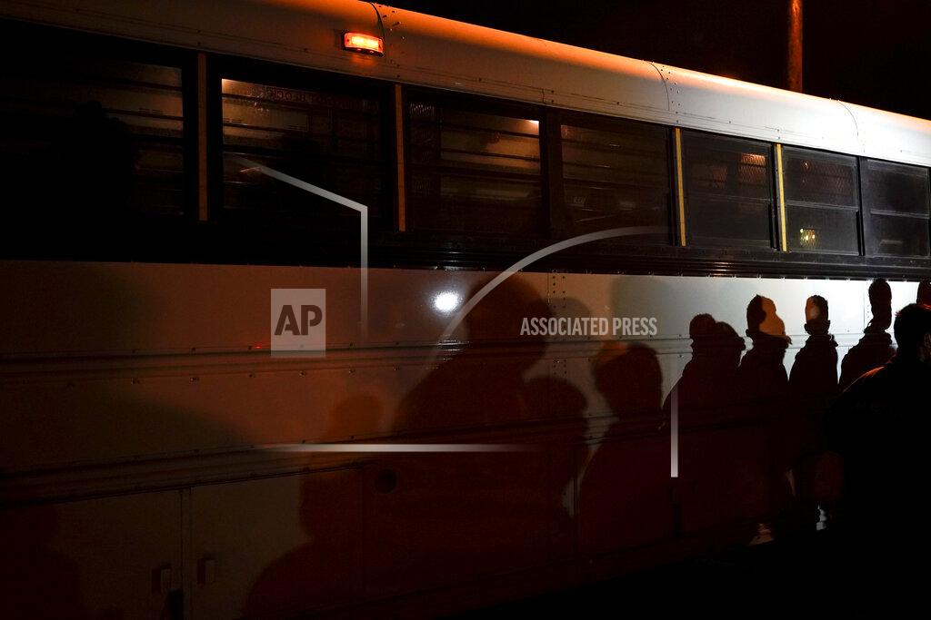 Gregory Bull FILE - In this May 11, 2021, file photo shadows of migrants lined up at an intake area are cast along the side of a bus after turning themselves in upon crossing the U.S.-Mexico border in Roma, Texas. President Joe Biden, under political pressure, agreed to admit four times as many refugees this budget year as his predecessor did, but resettlement agencies concede the number actually allowed into the U.S. will be closer to the record-low cap of 15,000 set by former President Donald Trump. (AP Photo/Gregory Bull, File)